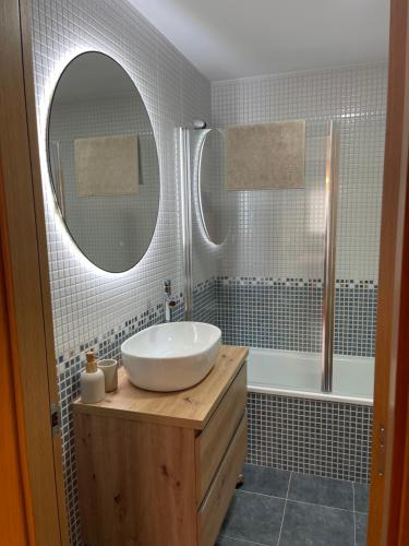 y baño con lavabo, espejo y bañera. en Apartamento en Boiro - Colores del Barbanza Rosa, en Boiro