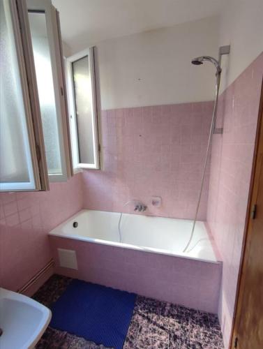 a pink bathroom with a tub and a sink at Maison du Port Du Goyen in Audierne