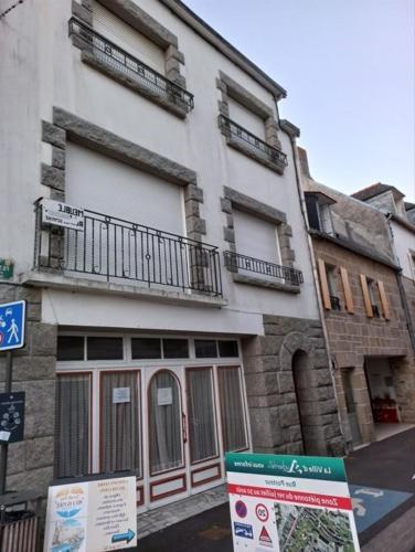a building with a sign in front of it at Maison du Port Du Goyen in Audierne