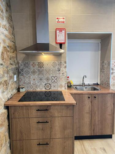 a kitchen with a stove and a sink at Cantinho D'Avó Maria in Zebreira