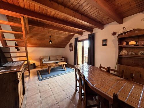 une cuisine avec une table et un salon avec un canapé dans l'établissement Résidence Le Coup De Sabre - LE COUP DE SABRE MAE-0011, à Vars