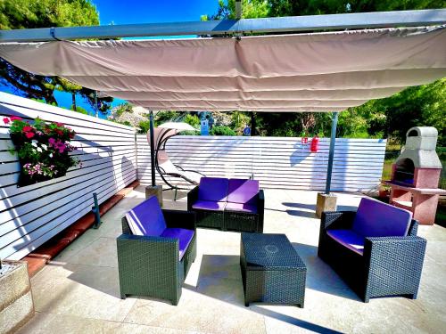 a patio with purple chairs and an umbrella at Villa Latino in Vieste