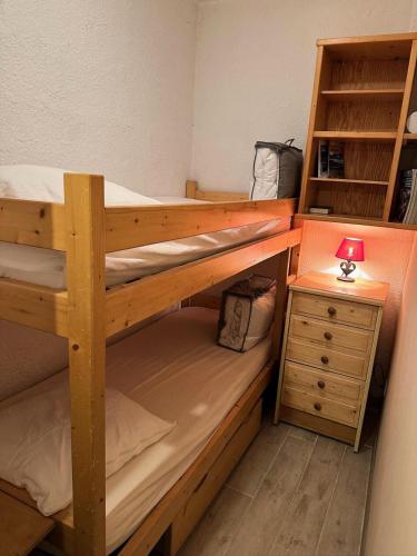- une chambre avec 2 lits superposés et une table de nuit dans l'établissement Résidence Neige Et Soleil - RESIDENCE NEIGE ET SOLEIL MAE-0041, à Vars
