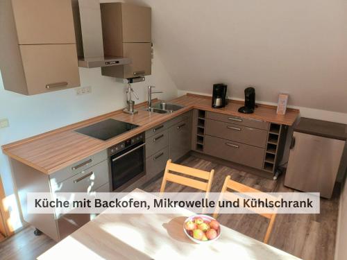 eine Küche mit einem Waschbecken und einem Tisch mit einer Schale Obst in der Unterkunft Ivy Haus in Falkensee