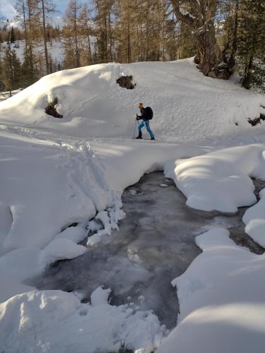 una persona en esquís en la nieve junto a un arroyo en Chalet Ory, en Vigo di Fassa