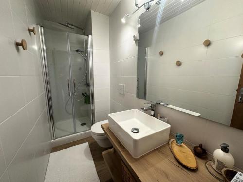 une salle de bain blanche avec un lavabo et une douche dans l'établissement Résidence La Piloselle - APPARTEMENT MODERNE MAE-2421, à Vars