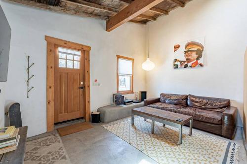ein Wohnzimmer mit einer Ledercouch und einem Tisch in der Unterkunft Modern Historic 1900 Adobe Bungalow in Downtown in Tucson