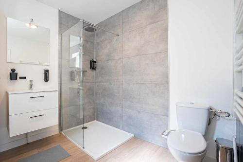 a bathroom with a toilet and a glass shower at Le Charlie - Lumineux - Spacieux - Jardin in Joeuf