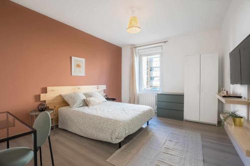 a bedroom with a bed and a table and a window at Le Charlie - Lumineux - Spacieux - Jardin in Joeuf