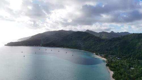 an aerial view of a beach with mountains at FARE Tatahi in Parea