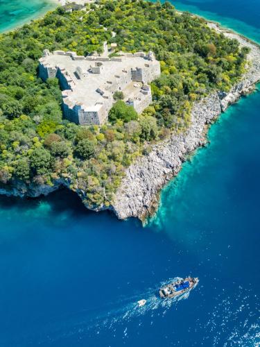 an island in the water with a boat in it at Hostel Hasta La Vista in Sarandë