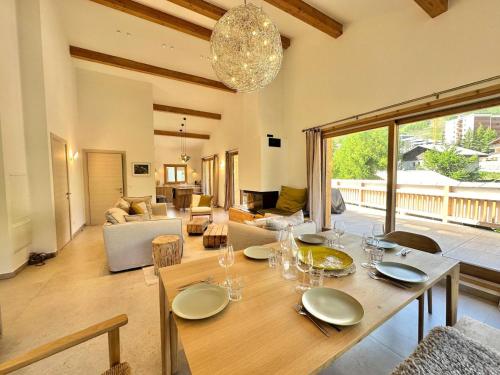une salle à manger avec une table et un salon dans l'établissement Résidence Le Solea - PENTHOUSE A LA MONTAGNE SAUNA ET SPA-Tout inclus MAE-2041, à Vars