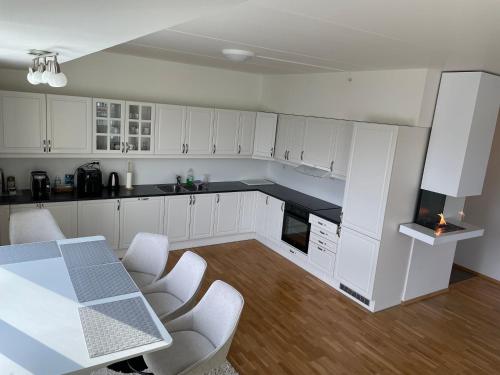 a kitchen with white cabinets and a table and chairs at Penthouse in Alta City in Alta