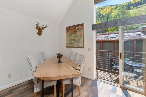a dining room with a table and a large window at Luxury Condo - Open for Bluegrass in Telluride