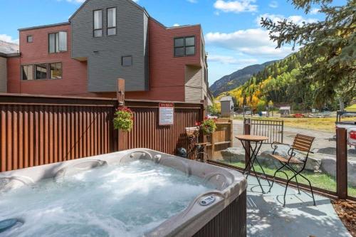 a hot tub in a yard next to a house at Luxury Condo - Open for Bluegrass in Telluride