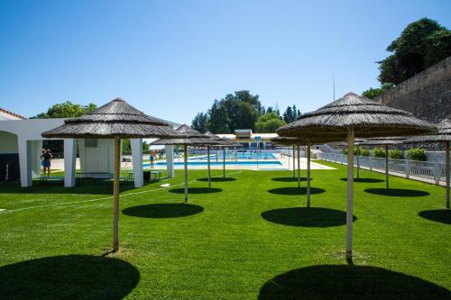 a group of umbrellas on the grass near a pool at Albergue Santa Justa in Moura