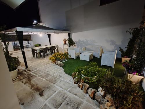 a patio with a table and chairs and an umbrella at Holiday House in Nardò