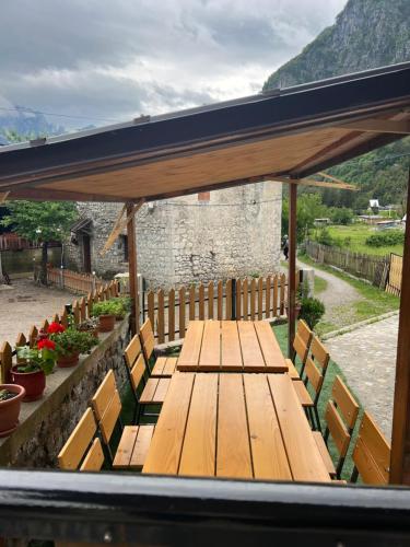 a wooden table and chairs under a pavilion at Guest House Shtëpiza Theth in Theth