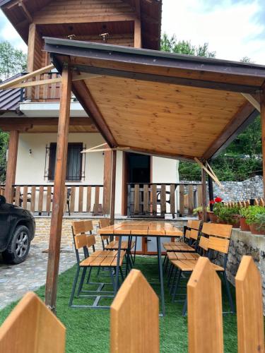 a picnic table and chairs under a pavilion at Guest House Shtëpiza Theth in Theth