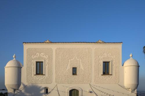 a building with two white domes on top of it at Torre Fiore Hotel Masseria in Pisticci