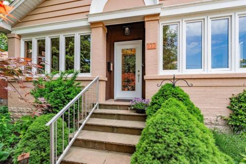 a pink house with stairs leading to the front door at Picturesque & Serene Gem in Port Credit - Steps to Lake - Backyard in Mississauga