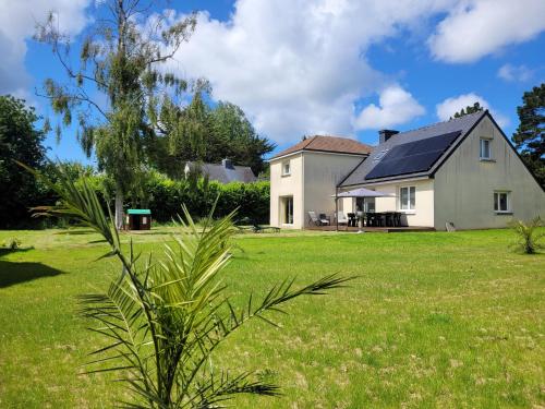 a house with a green yard with a plant at Kernay, grande maison familiale pour 10 personnes in Lannion