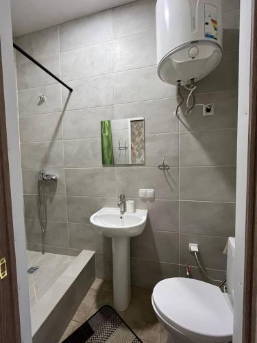 a bathroom with a sink and a toilet and a shower at Отель Меридиан in Zolotonosha