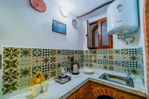 una cucina con lavandino e piastrelle sul muro di Splendid traditioanal house in the main square a Chefchaouen