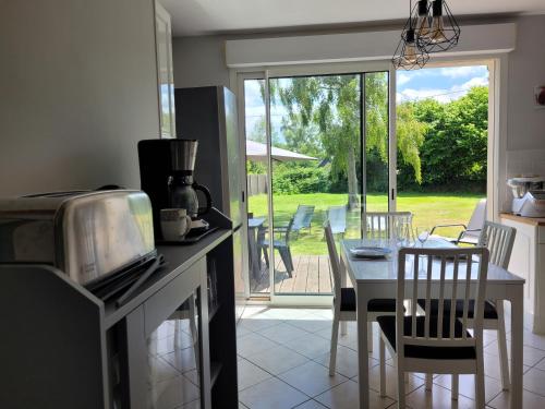 a kitchen with a table and chairs and a dining room at Kernay, grande maison familiale pour 10 personnes in Lannion