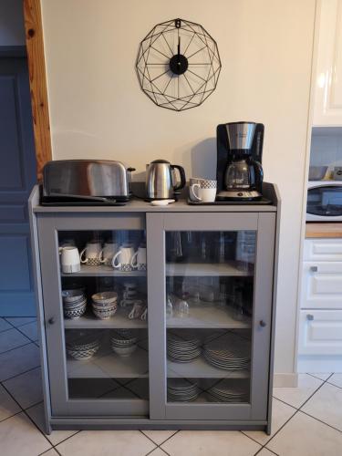 a cabinet filled with dishes and pots and pans at Kernay, grande maison familiale pour 10 personnes in Lannion