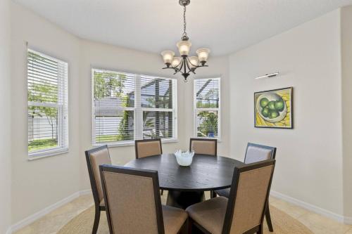 a dining room with a black table and chairs at Salty Reef Pool Home | Palm Coast in Palm Coast