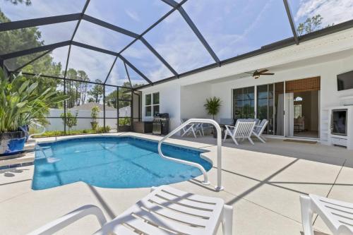 a swimming pool in a house with a glass roof at Salty Reef Pool Home | Palm Coast in Palm Coast