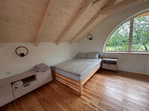 a bedroom with a bed and a large window at Farma Albert Korzenie in Pruchnik-Miasto