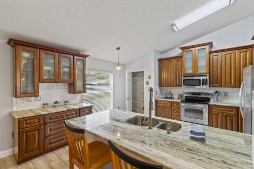 una cucina con mobili in legno e un piano di lavoro di Sandpiper Path | Palm Coast a Flagler Beach