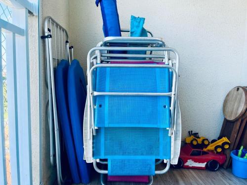 a blue beach chair in a room with toys at Apto 6º andar, 200m praia, 15min Beto Carrero, 2 quartos, sacada com churrasqueira in Piçarras