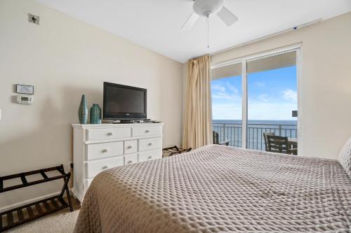 una camera da letto con un letto, una televisione e un balcone di 607-E-Splash a Panama City Beach