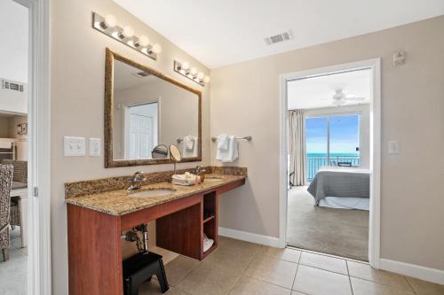 un bagno con lavandino e specchio e una camera da letto di 607-E-Splash a Panama City Beach