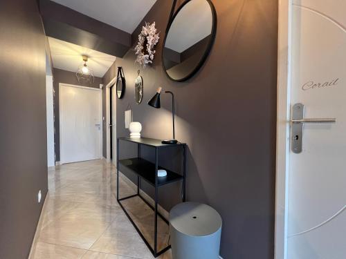 a bathroom with a mirror on the wall and a stool at La Villa des Cistes au calme vue Étangs in Narbonne