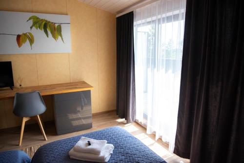 a bedroom with a bed and a desk and a window at Hiiumaa Sõru Puhkemaja in Sõru