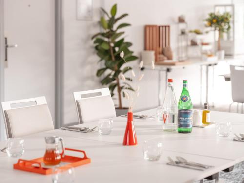 a white table with bottles and glasses on it at Holiday Inn Toulouse Airport by IHG in Blagnac