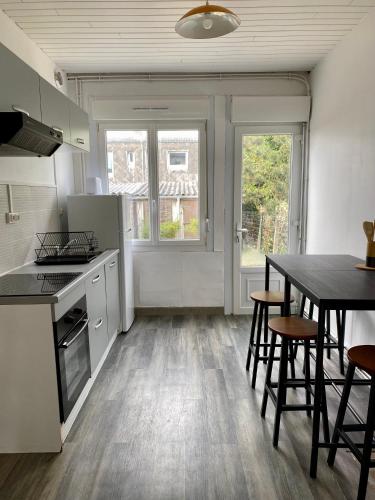 une cuisine et une salle à manger avec une table et des chaises dans l'établissement Les Passe-Pierres, à Merlimont