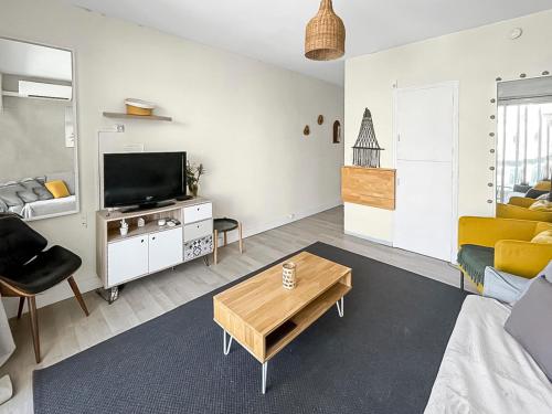 un salon avec un canapé et une télévision dans l'établissement Évasion Balnéaire à La Grande-Motte, à La Grande Motte