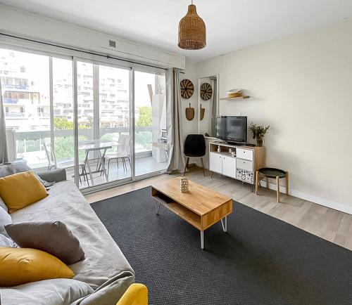 un salon avec un canapé et une table dans l'établissement Évasion Balnéaire à La Grande-Motte, à La Grande Motte