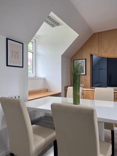 Un comedor con una mesa y sillas blancas. en ROYAL RACiNG SUiTE, en Judenburg