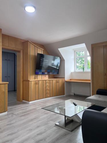 a living room with a tv and a glass table at Royal Racing Suite Top 1 near Red Bull Ring in Judenburg