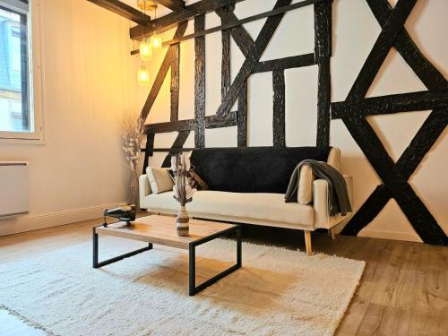 a living room with a white couch and a table at La Dame Blanche - Appartement hypercentre historique - Parking privé in Bourges