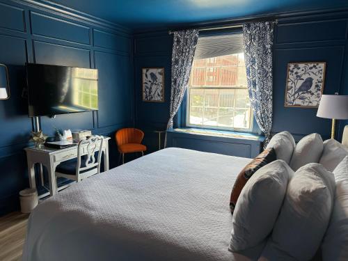 a blue bedroom with a bed and a television at Spokane Club Hotel in Spokane