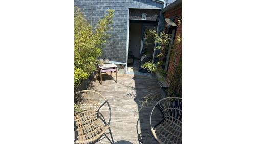 a patio with two chairs and a table at La maison du tripot in Honfleur