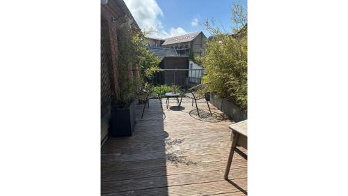 a wooden walkway in a garden with benches at La maison du tripot in Honfleur