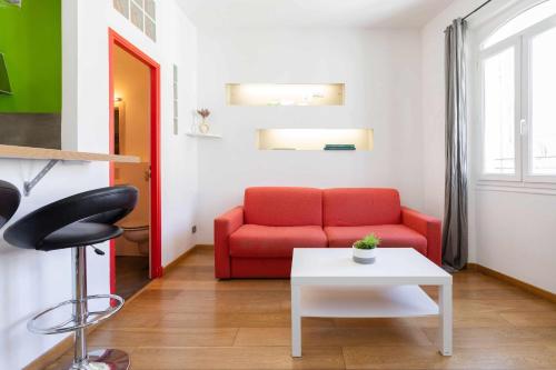 un salon avec un canapé rouge et une table dans l'établissement Apartment in the heart of the Old Port, à Marseille